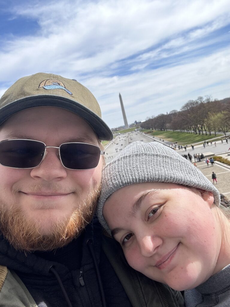 A Selfie of my fiance and I, standing on the steps of the Lincoln memorial, with the Washington Monument in the background.